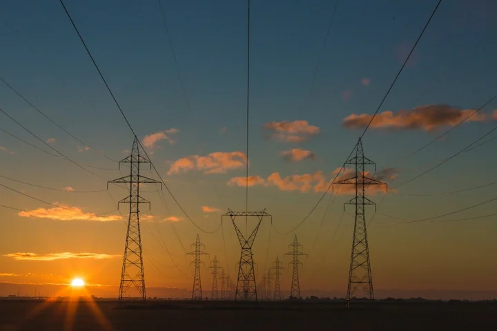Electricity transmission towers and power lines at sunset