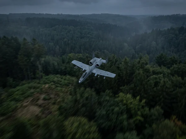 AI-generated aircraft flying above a forest under dark skies with motion blur